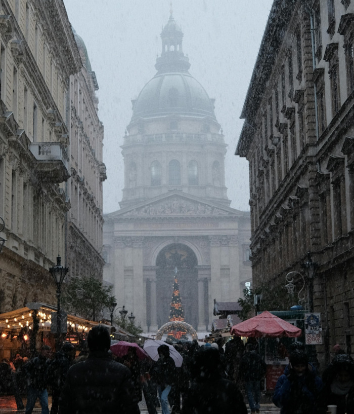 Bazilika Sv. Stjepana prekrivena maglom i snijegom, ljudi na ulici prolaze