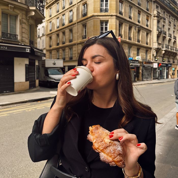 Ana pije kavu i jede kroasan u Parizu
