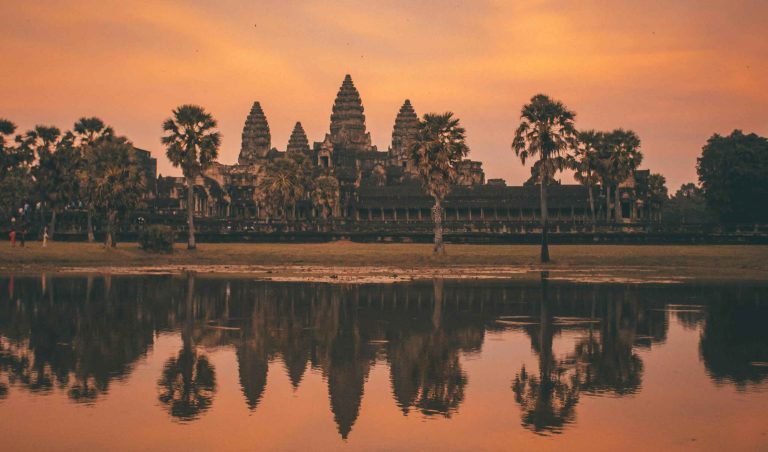 Angkor Wat zalazak sunca, odsjaj tornjeva u vodi i nebo narančaste boje.