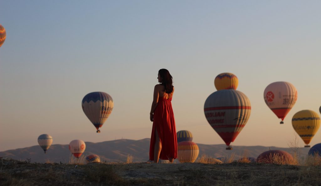 Ana Mihaljevic u Kapadokiji, baloni na nebu u pozadini.