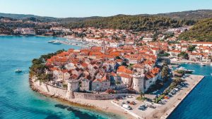Old town Korčula panorama, orange roofs and deep blue sea water.