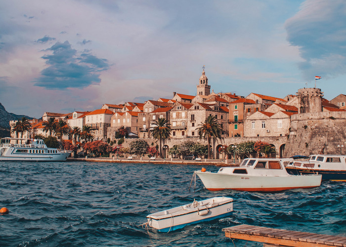 Stari grad Korčula, barke, more i narančasti krovovi.