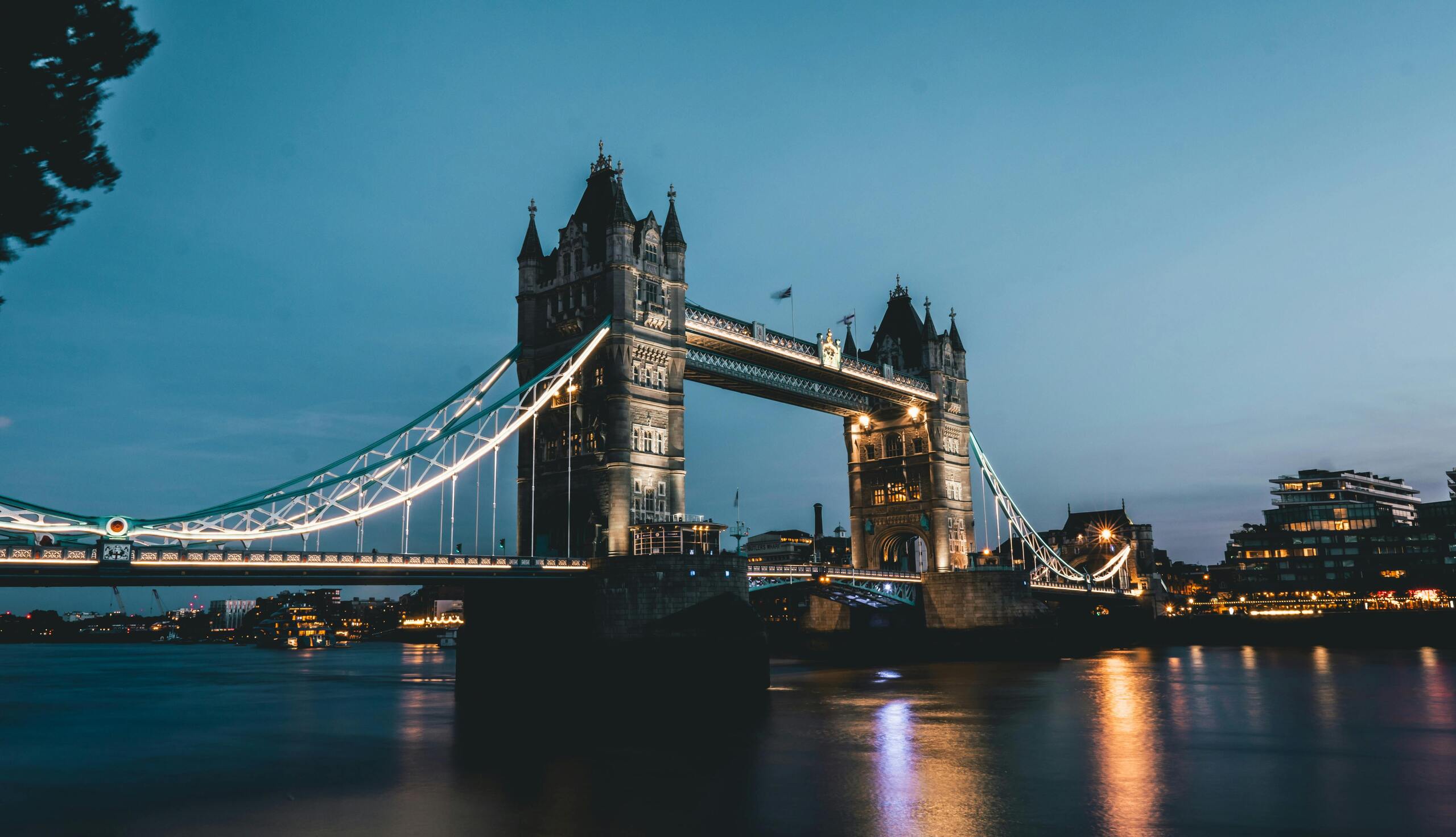 Tower Bridge u sumrak, obasjan svjetlima.