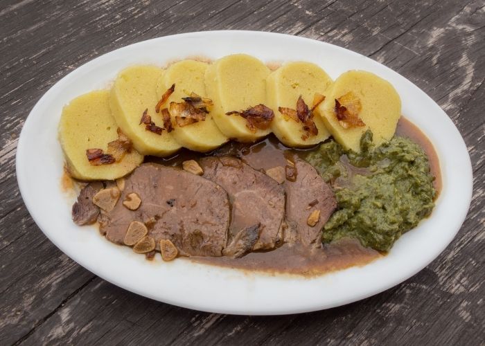Czech food, duck with dumplings and spinach.