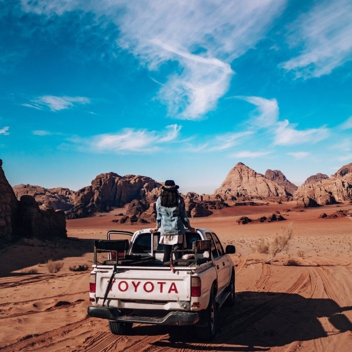 Ana na Toyota autu u Wadi Rum pustinji, stijene i nebo u pozadini