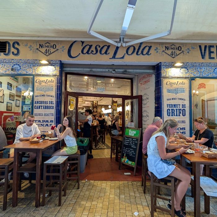 Pročelje restorana Casa Lola, ljudi i barski stolovi