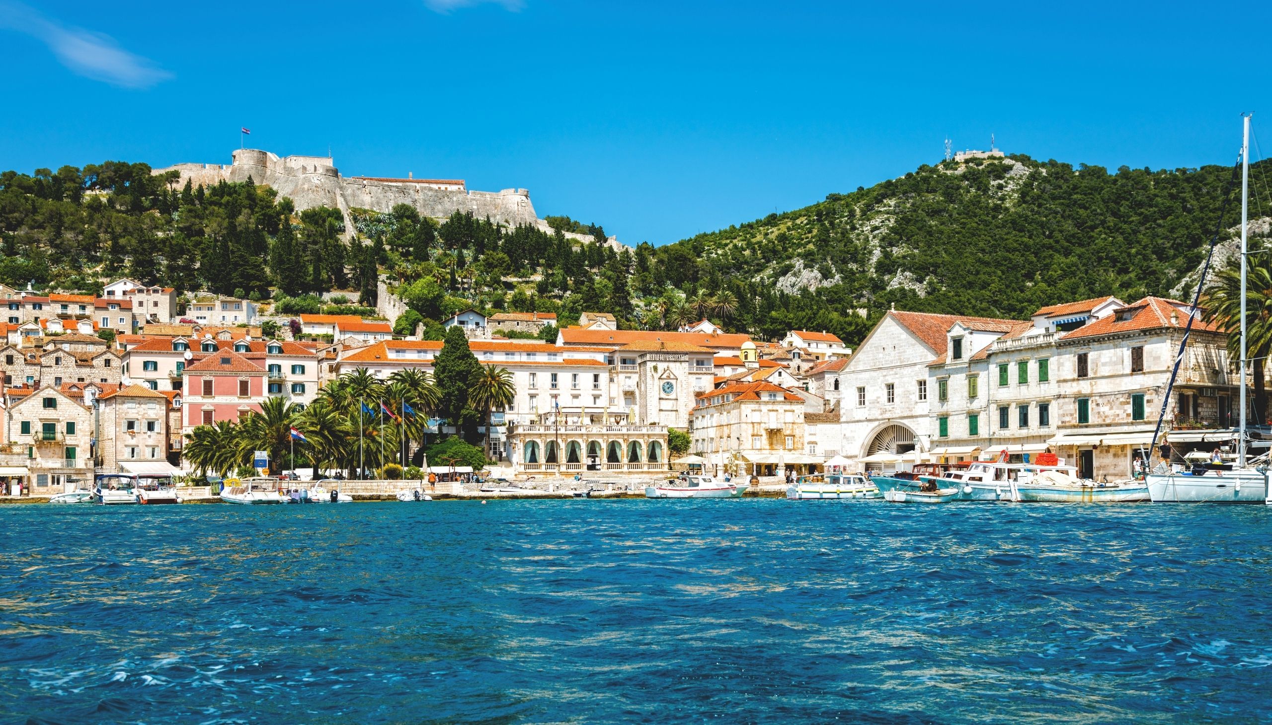 Pogled na luku u Hvaru s mora i tvrđavu iznad