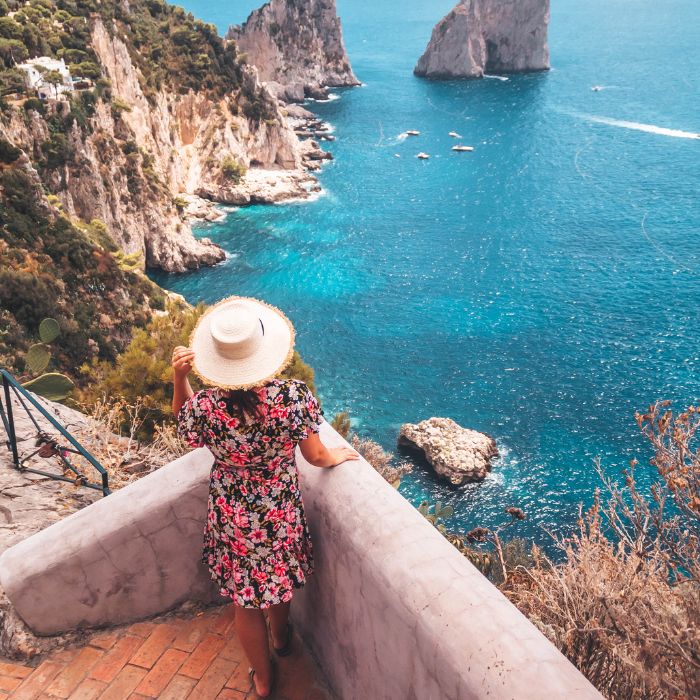 Ana sa šeširom i pogled na stijene i modro more na Capriju