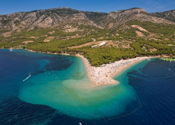 Zlatni Rat iz zraka, zaobljena plaža, plavo more i zelenilo
