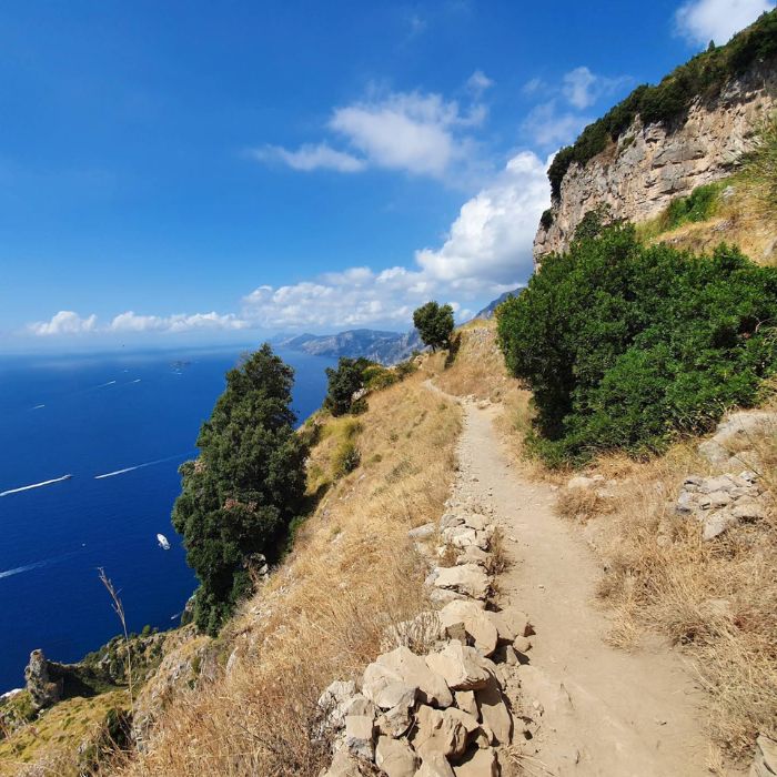 Zemljani put uz strminu, s lijeve strane plavo more