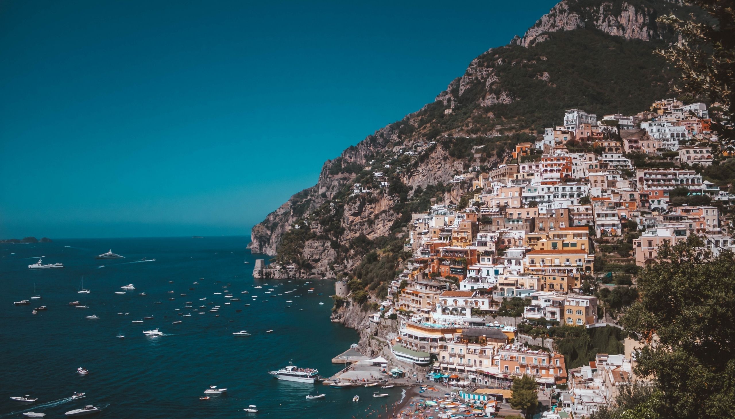 Kuće na brdu u Positanu te plaža i brodovi ispod njega