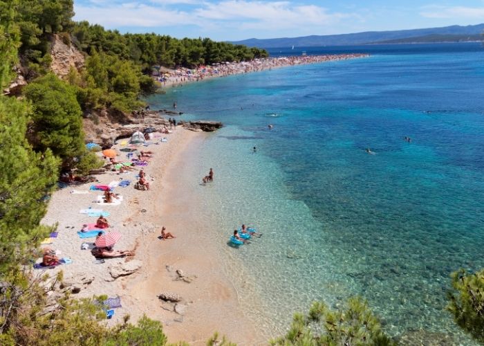 Zaobljena smeđa šljunčana plaža na Braču i plavo more