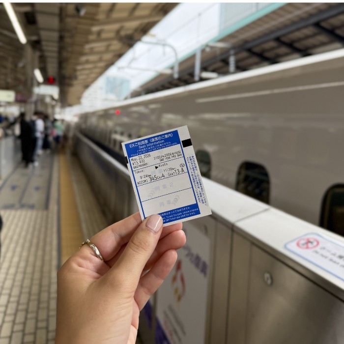 Karta za Shinkansen u ruci i vlak u pozadini