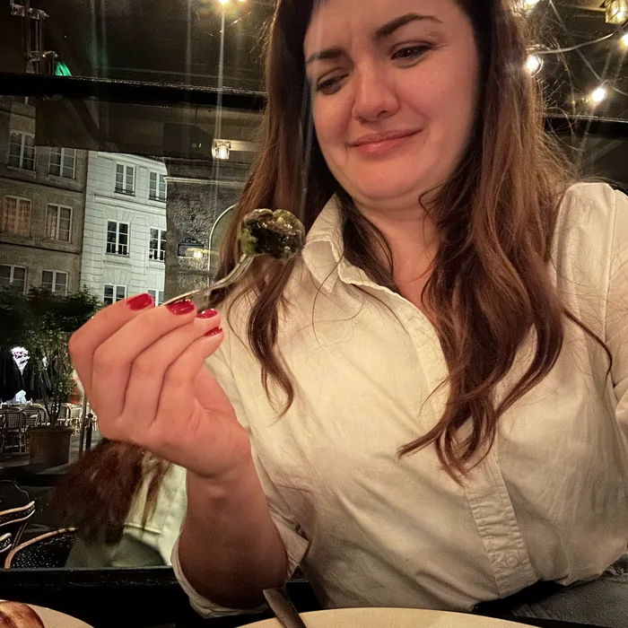 Ana nepovjerljivo gleda puža na vilici u pariškom restoranu