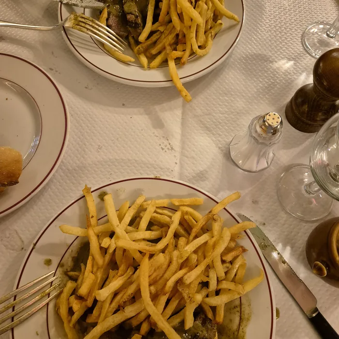 Dvije porcije steaka s umakom i velikom količinom pomfrita u Le Relais de l’Entrecôte