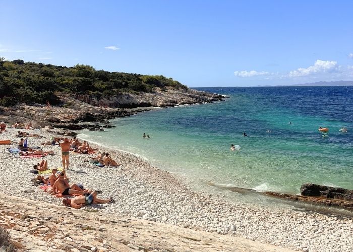 Stjenovita gola plaža sa kamenčićima, plavo more