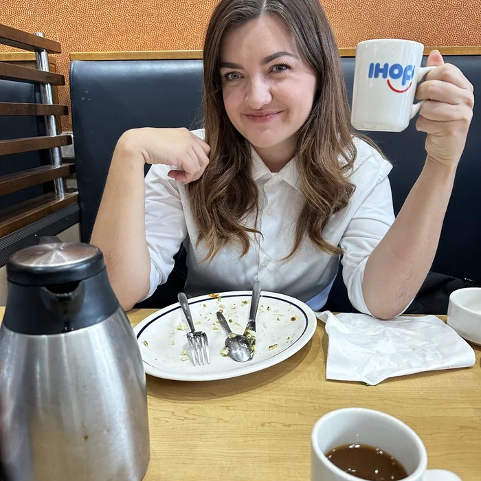 Ana drži šalicu kave za stolom u restoranu IHOP.