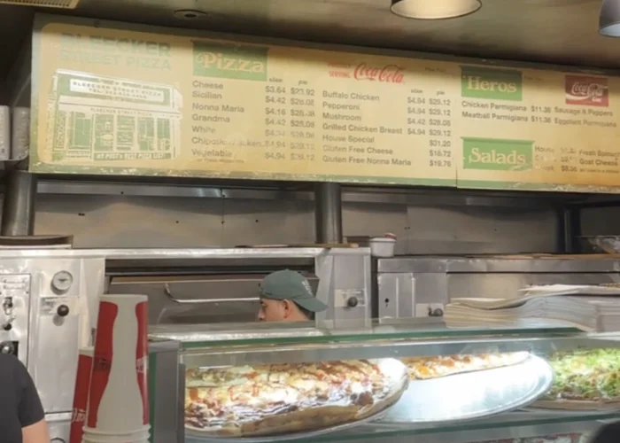 Pult s pizzama i cjenikom u Bleecker Street Pizzi u New Yorku.