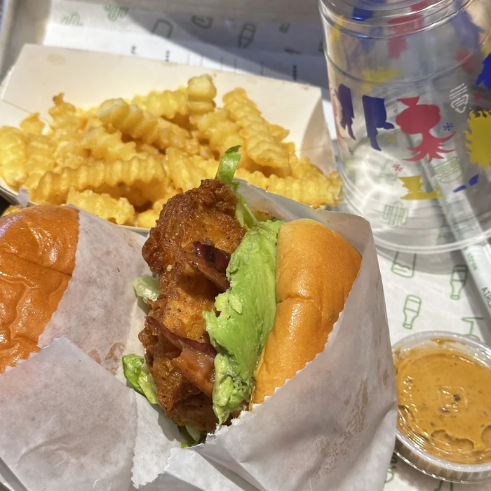 Sendvič s piletinom, avokadom i slaninom uz waffle fries u Chick-fil-A restoranu.