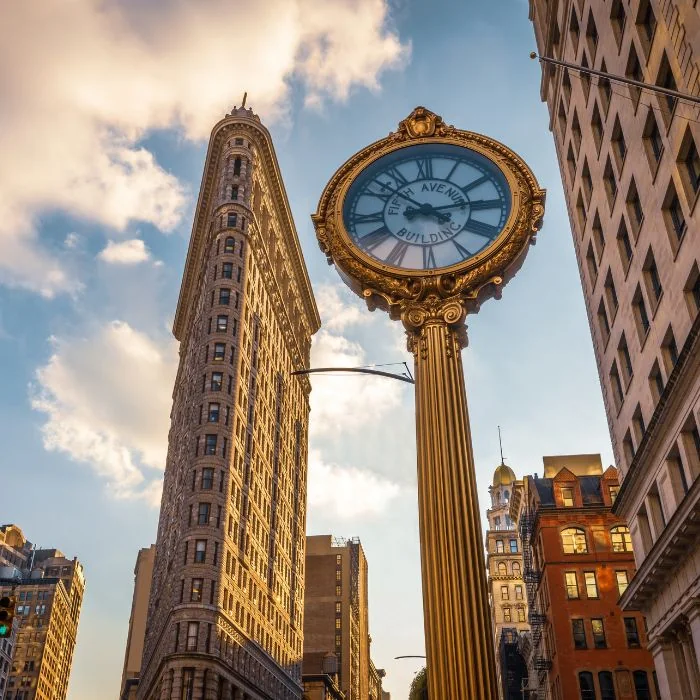 Flatiron Building i ulični sat na Petoj aveniji u New Yorku.