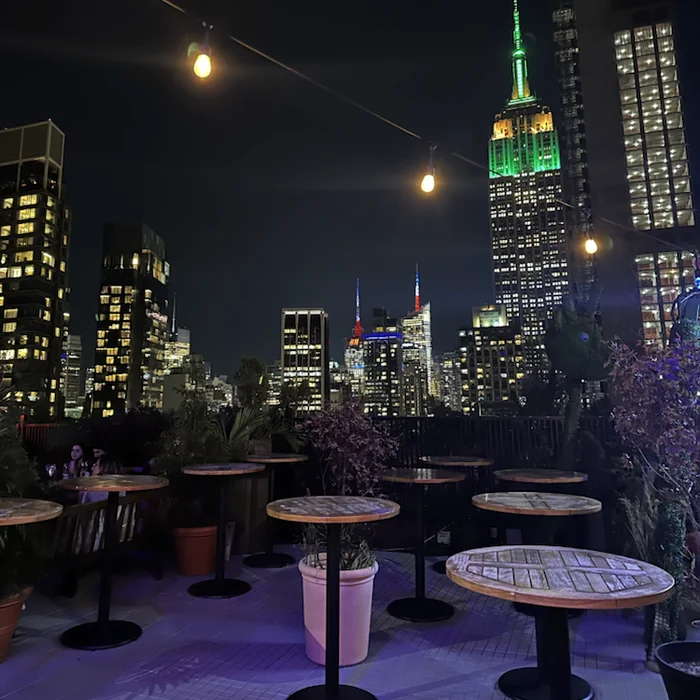 Noćni pogled na Empire State Building s rooftop bara u New Yorku.